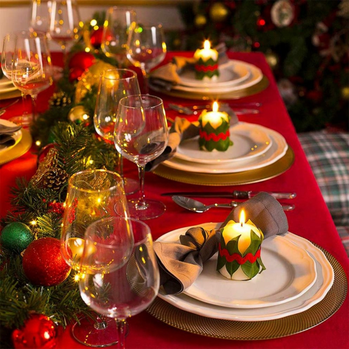 assiettes blanches, verres à vin, nappe rouge, branches de pin, nappe de table rouge, déco de table pour Noël