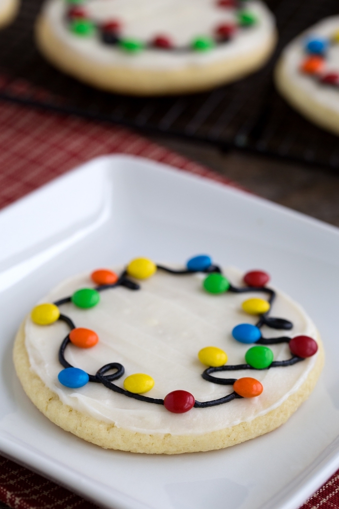 sable de noel facile et rapide, cookies ronds avec glaçage royal et mini bonbons en forme guirlande lumineuse de noel