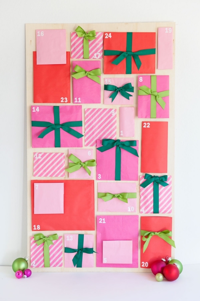 joli calendrier de l'avent à fabriquer soi-même à partir d'une planche de contreplaqué et des pochettes cadeaux de tailles et de couleurs différentes