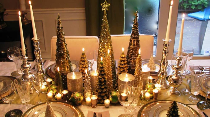 arrangement de table de Noel, jolis sapins de noel, bougies allumées, boules décoratives, bougeoirs argentés, chemin de table doré