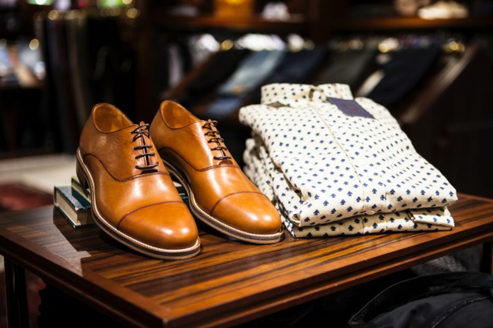 codes vestimentaires pour l'homme moderne, chemises pliées à sapins, chaussures camel, table en bois laqué