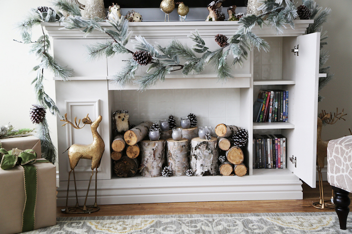 meuble décoration fausse cheminée en bois blanc avec rangements type commode comme support tv avec déco de noel scandinave avec buches en bois