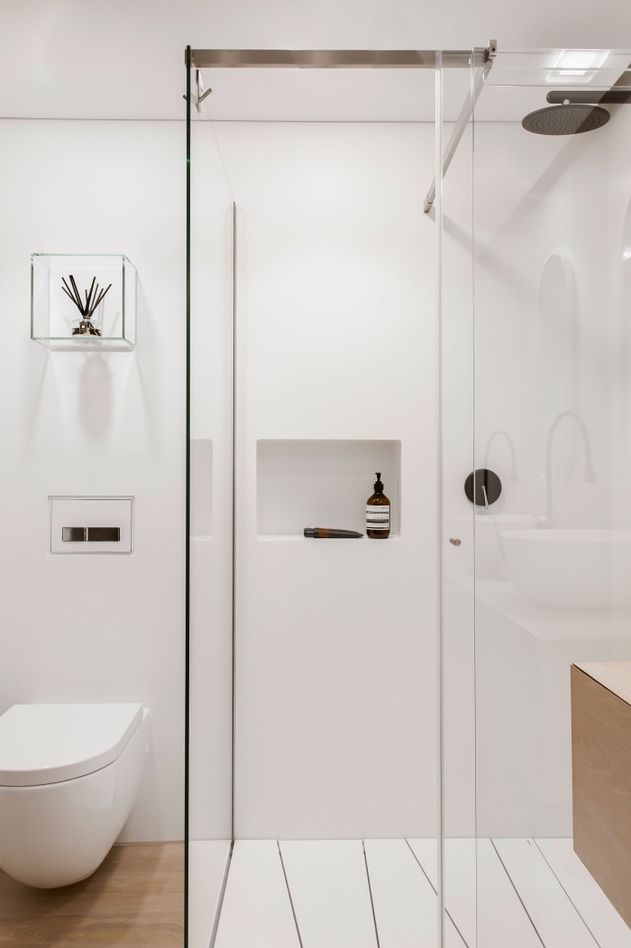 salle de bain scandinave avec murs blancs et revêtement sol imitation parquet bois, astuce rangement murale avec niche