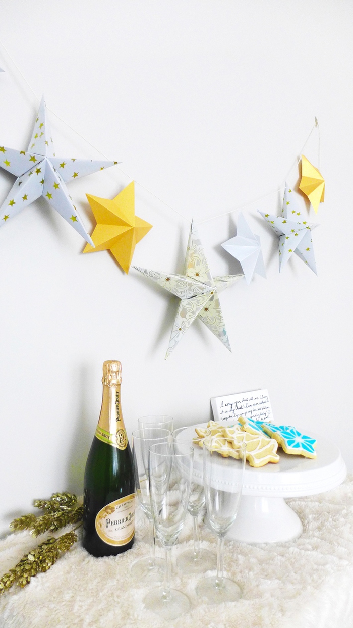 guirlande de noël avec des étoiles origami 3d pliées à la main, suspendu en dessus le buffet de nouvel an 