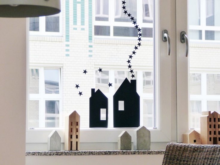 deco fenetre noel minimaliste avec des stickers autocollants maisons noires et des maisons décoratives en bois sur le rebords