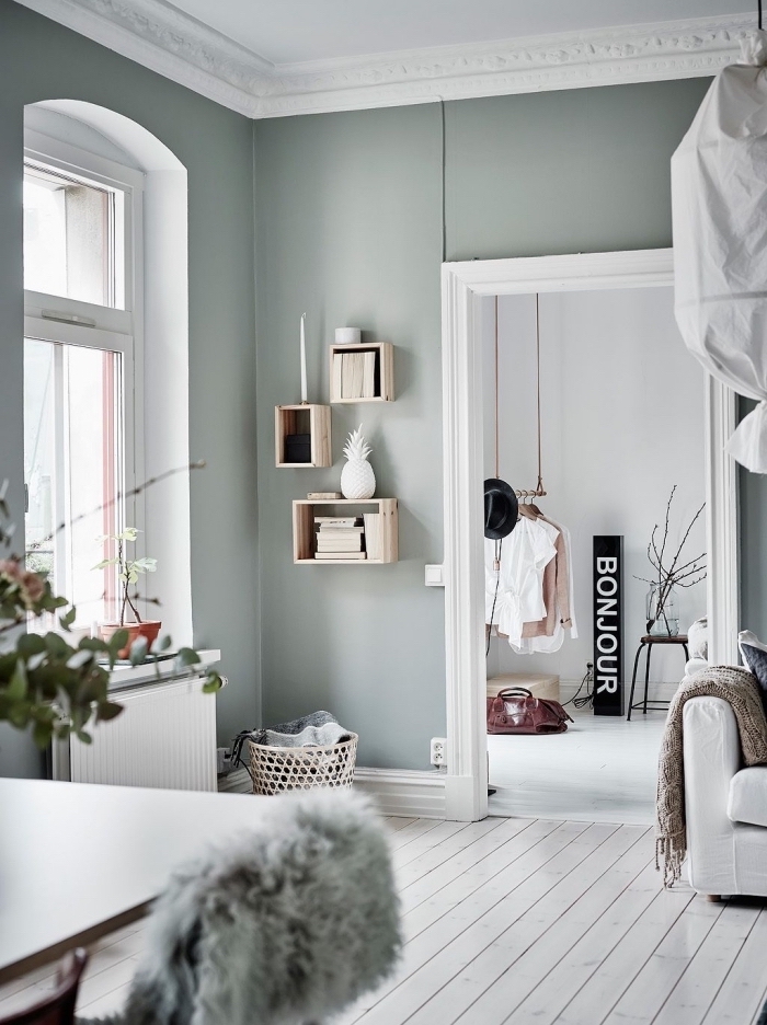 aménagement de salon scandinave aux mur gris, déco pièce bicolore en blanc et vert pastel avec meubles de bois