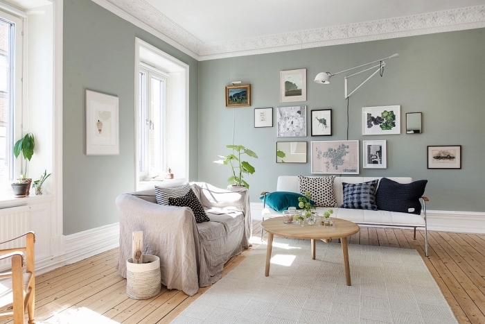 ambiance relaxante dans un salon en couleurs neutres, idée peinture grise verdâtre, exemple mur de cadres blanc et noir