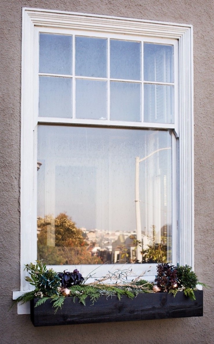 un bac à fleur avec une composition végétale et des branches lumineuses qui égaiera le rebord extérieur de la fenêtre, idee deco noel a faire soi meme pour décorer l'extérieur de la maison