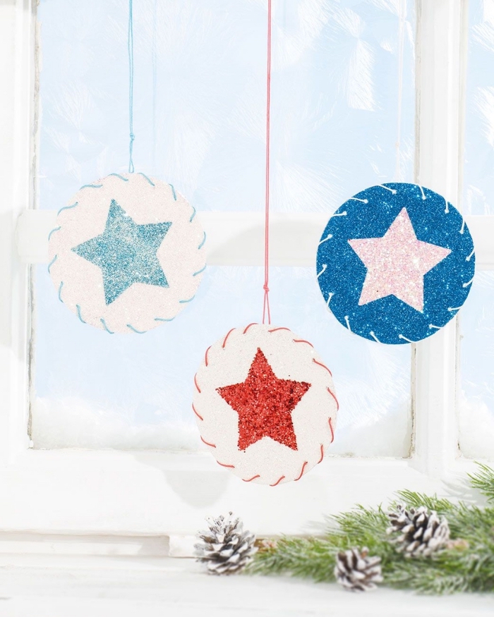 idée de décoration de noel à fabriquer en papier, des suspensions de noël en ronds de papier à motif étoile pailletée suspendues à la fenêtre