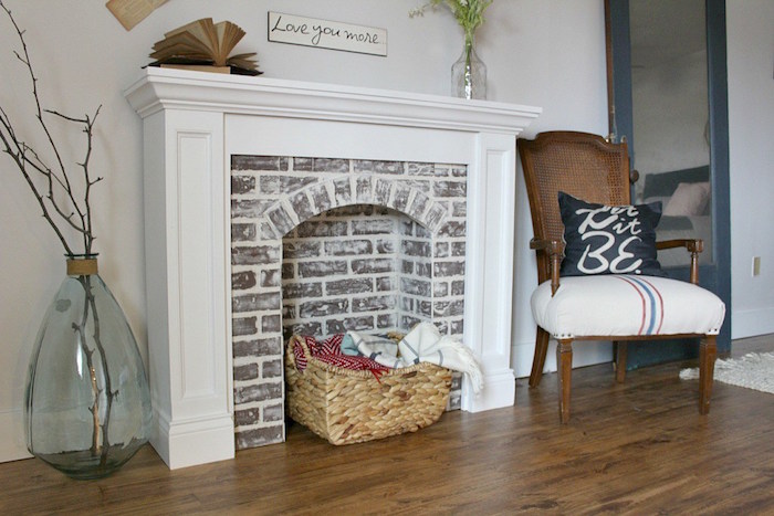 meuble mural imitation cheminée avec manteau blanc et faux foyer en fausses briques pour déco de salon retro cosy rustique