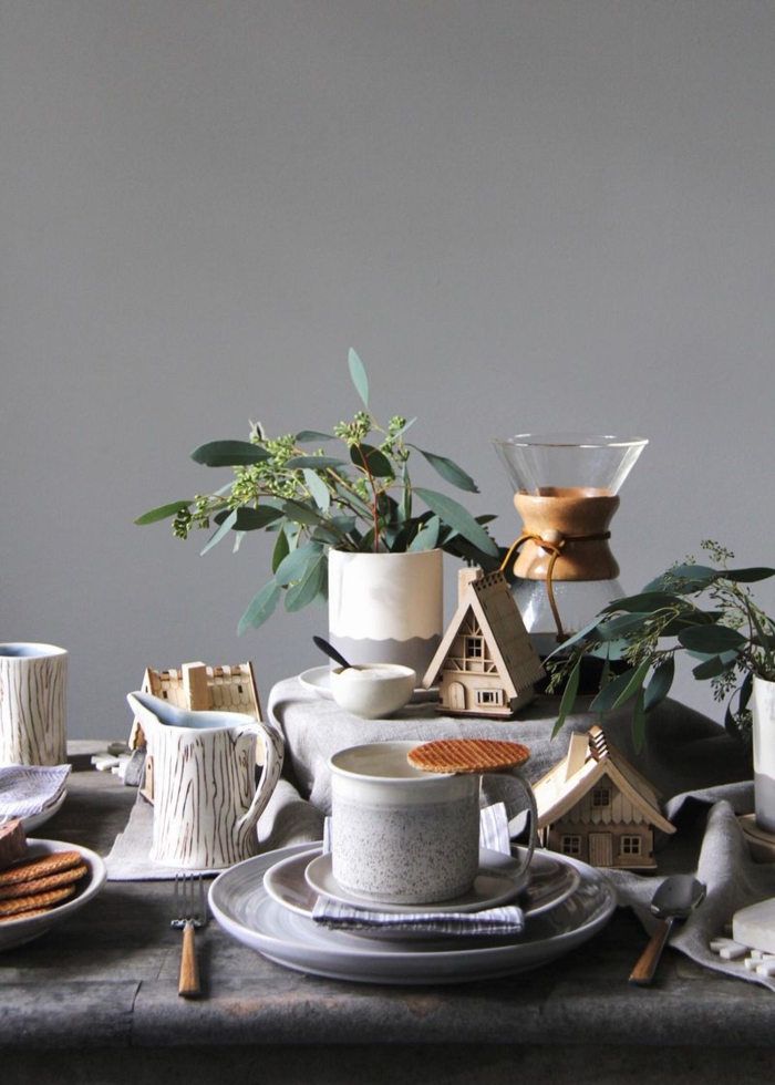 décoration de noel style scandinave, tasses à café, théière, brins verts, mur gris clair