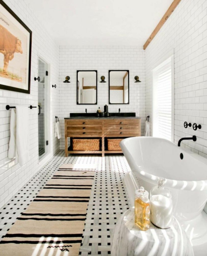 jolie salle d'eau, tapis beige aux rayures noires, meuble sous vasque bois usé, carreaux muraux blancs, grande photographie encadrée