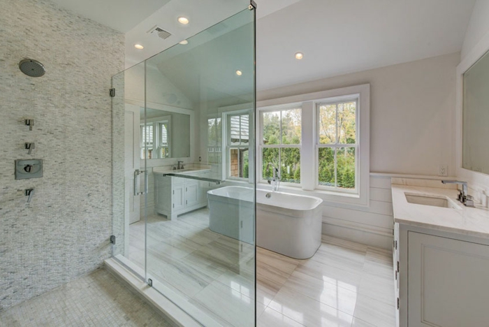 salle de bain blanche, grande salle avec baignoire céramique, douche minimaliste, spots au plafond, meuble vasque blanc
