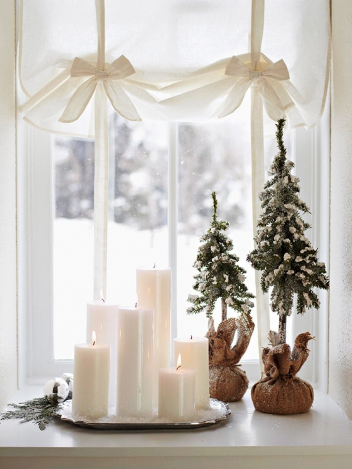 deco noel a fabriquer soi-même avec des bougies blanches de tailles différentes disposées sur un plateau et des mini-arbres de noël en sac en jute, décoration rebord de fenêtre naturelle et minimaliste