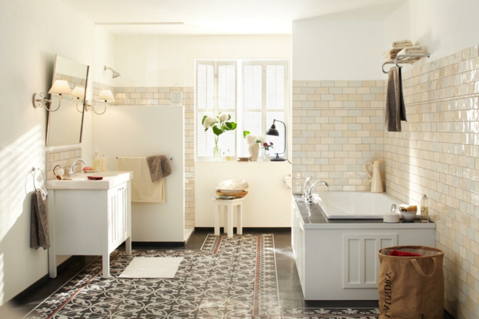 carreaux de ciment motifs marocains, lavabo blanc, meuble salle de bain blanc, baignoire à encastrer, carreaux métro beiges, tabouret blanc, deux fenêtres