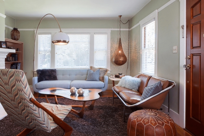 aménagement salon aux murs vert pastel, déco avec meubles bois, design intérieur traditionnel avec meuble bois et cuir