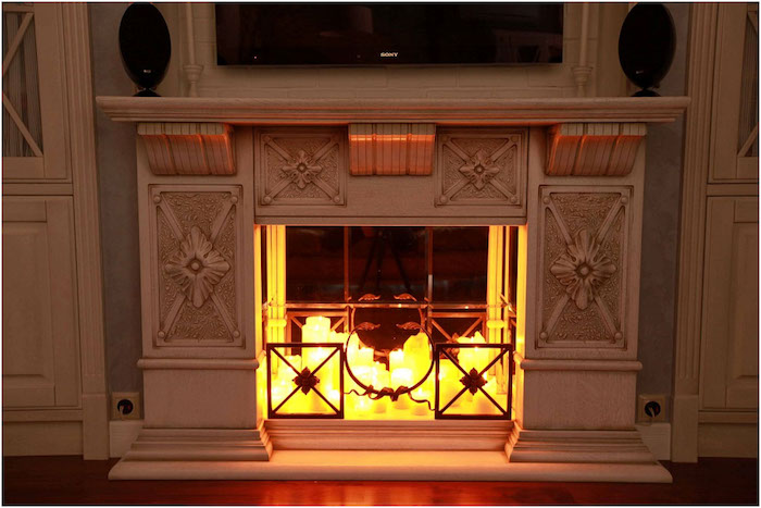 meuble imitation cheminée déco sculpté avec lot de bougies deco dans insert style faux feu avec tv murale