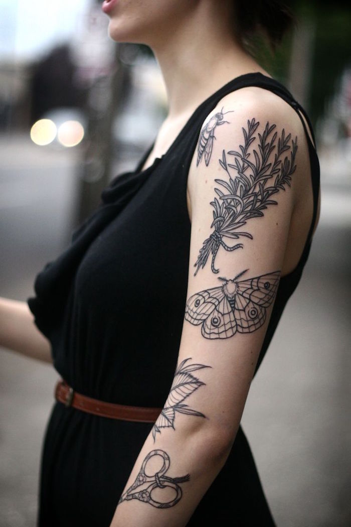 femme avec tatouages sur le bras en noir en blanc avec insectes et plantes sur épaule et manche