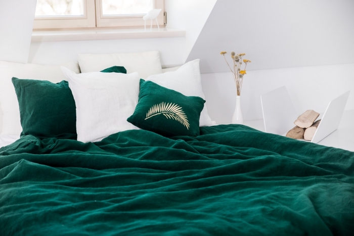 ambiance cozy dans une chambre sous combles, idée peinture murale tendance, déco de chambre blanche avec accessoires en vert foncé