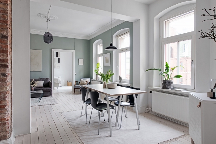 déco scandinave dans un appartement au plafond blanc et murs verdâtres, peinture salle a manger vert pastel