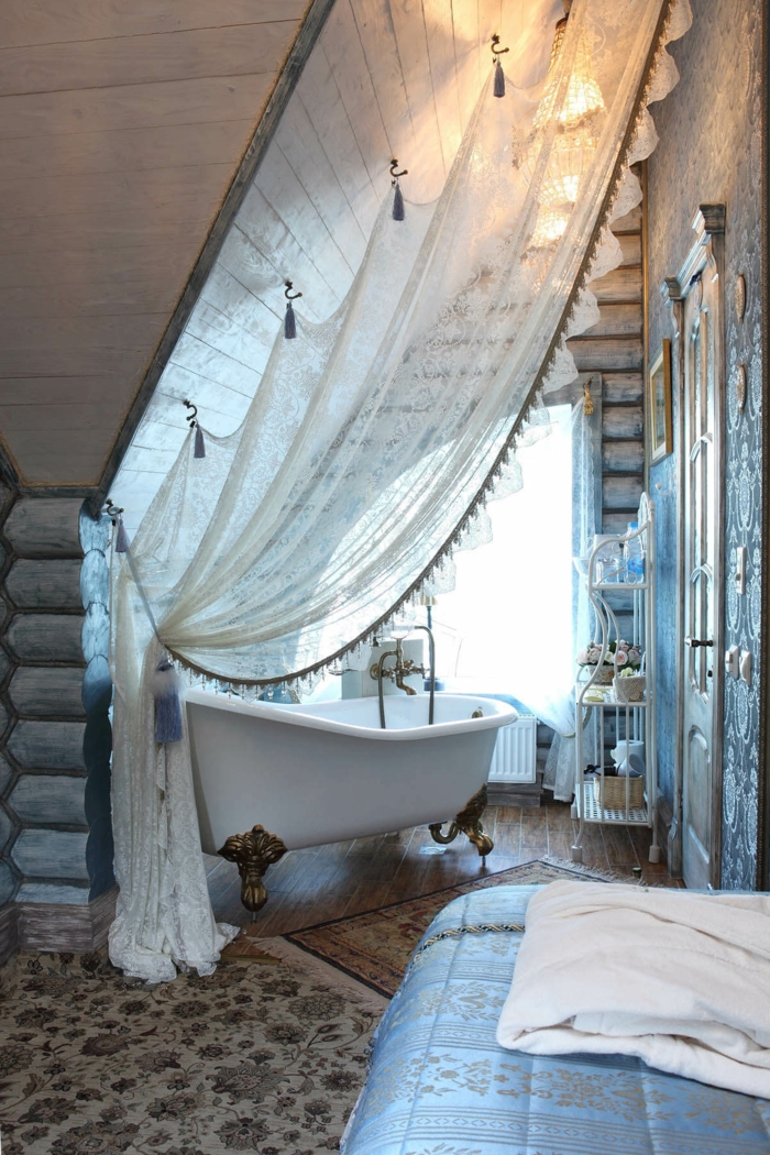 sol en pierre et tapis persan, rideau blanc, baignoire blanche, grande banquette maçonnée, déco d'intérieur style vintage rustique