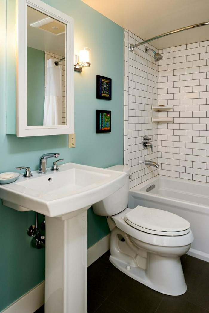 aménager une petite salle de bain, mur bleu, carreaux métro, petites peintures abstraites, baignoire rectangulaire