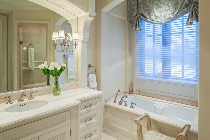 salle de bain 5m2, grand miroir au-dessus de vasque élégante couleur crème, rideau vert shabby, tabouret aux formes courbées