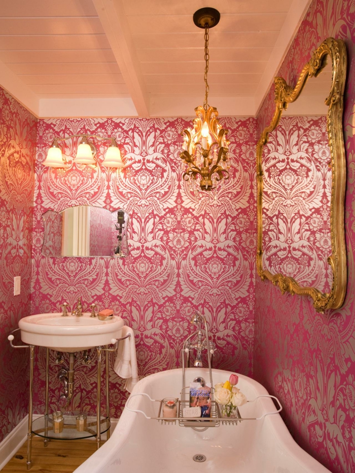 baignoire blanche, papier peint rose baroque, miroir cadre baroque et luminaire suspendu, vasque ronde; petit miroir décoratif
