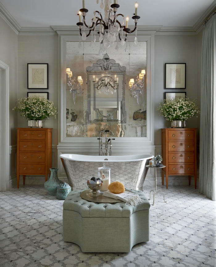 ottoman gris capitonné, baignoire couleur argent, appliques élégantes, meubles en bois laqué, grand miroir rectangulaire