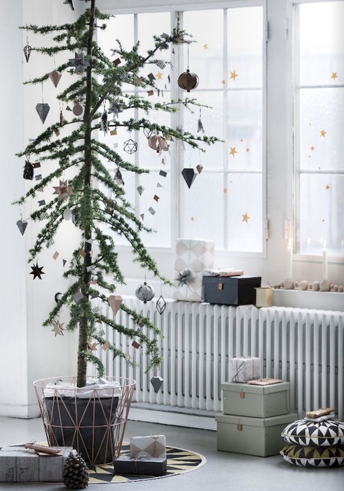 des stickers petites étoiles dorées qui ornent les vitres du salon scandinave blanc, déco de noël minimaliste scandinave avec un arbre de noël vert en pot agrémenté d'ornements vintage