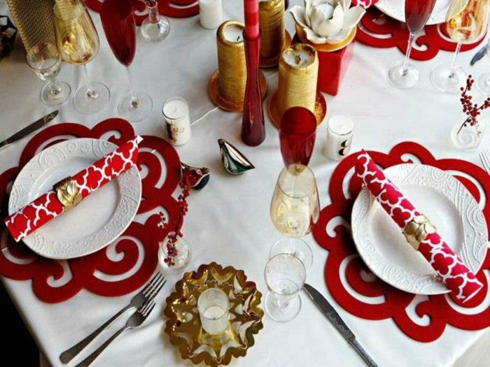 déco de table de noel, assiettes blanches, sous-assiettes rouges, bougeoirs couleur d'or, nappe blanche