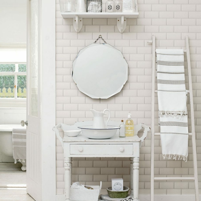 salle de bain blanche, miroir rond, carreaux métro, échelle blanche, rayon bois blanc, carafe et ustensiles rétro