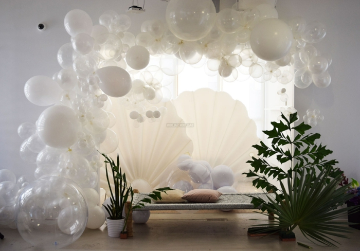 salle de séjour, arche de ballons blancs, plantes vertes, salon gris, grand coquillage blanc