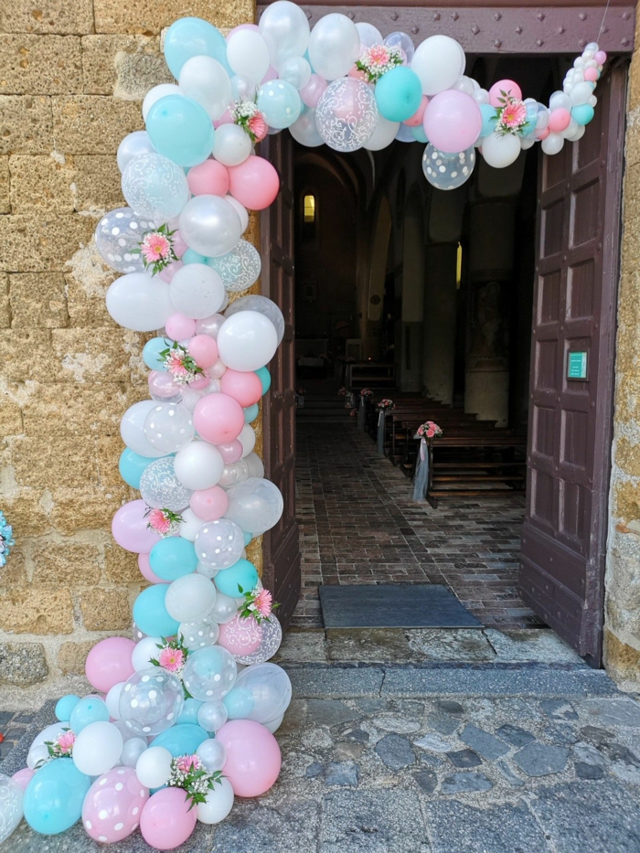 arche de ballons décorés de jolies roses à l'entrée de l'église, banquettes décorées pour la cérémonie d'un mariage champêtre