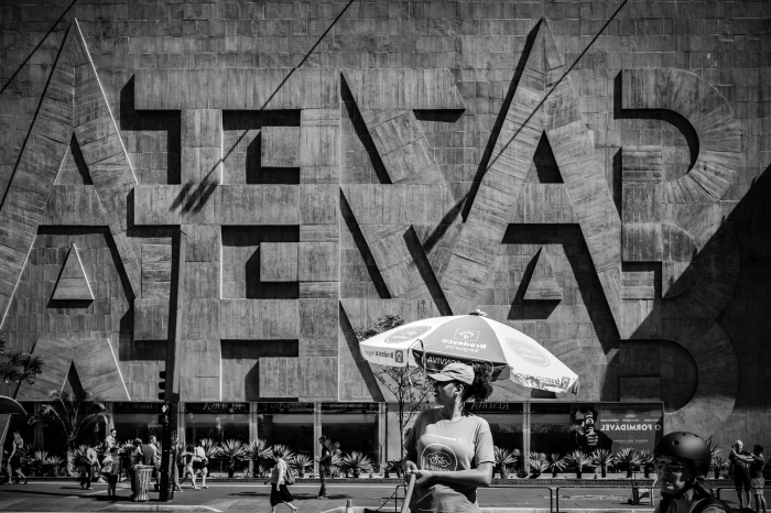 une photo noir et blanc femme dans la rue qui se tient devant la façade d'un bâtiment au brésil