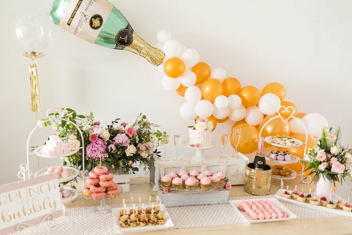 ballon bouteille de champagne, plusieurs ballons rassemblés qui sortent de la bouteille de champagne, ballons jaunes et blanches, bouchés sucrées apétissantes