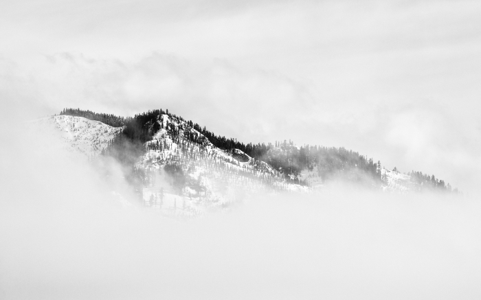 un paysage hivernal en noir et blanc de montagne enveloppée de brumes, photographie de paysage monochrome