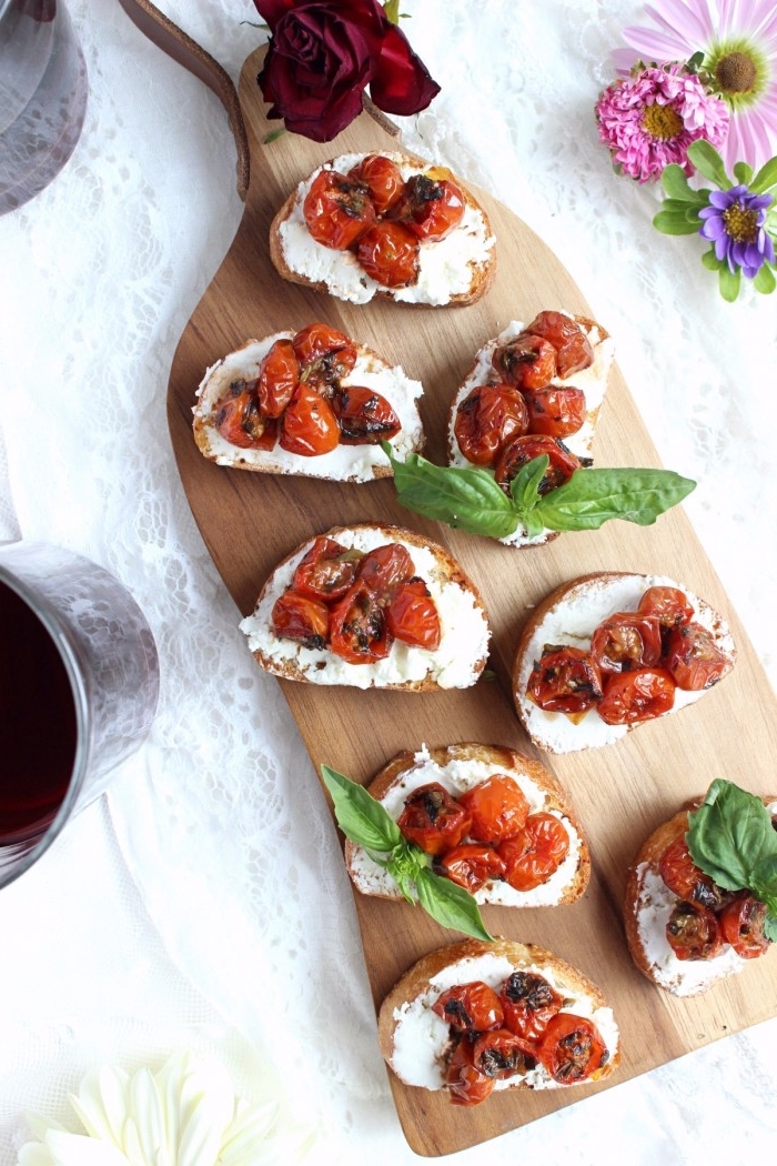 recette bruschetta tomate cerise séchée et fromage de chèvre crémeuse, décorée avec des feuilles de basilic