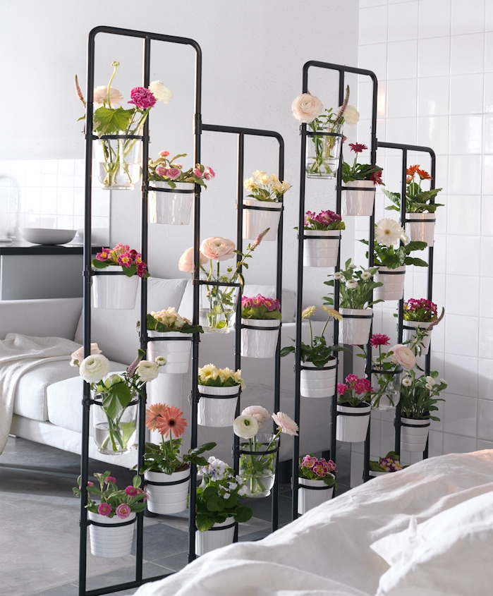 mur végétal intérieur, cloison de séparation métallique avec des pots de fleurs blanches, canapé blanc et murs blancs