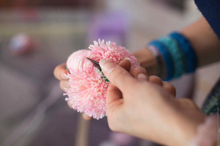 fabriquer un pompon avec ses mains et un ciseau, pompon en fil rose, pompon de laine décoratif