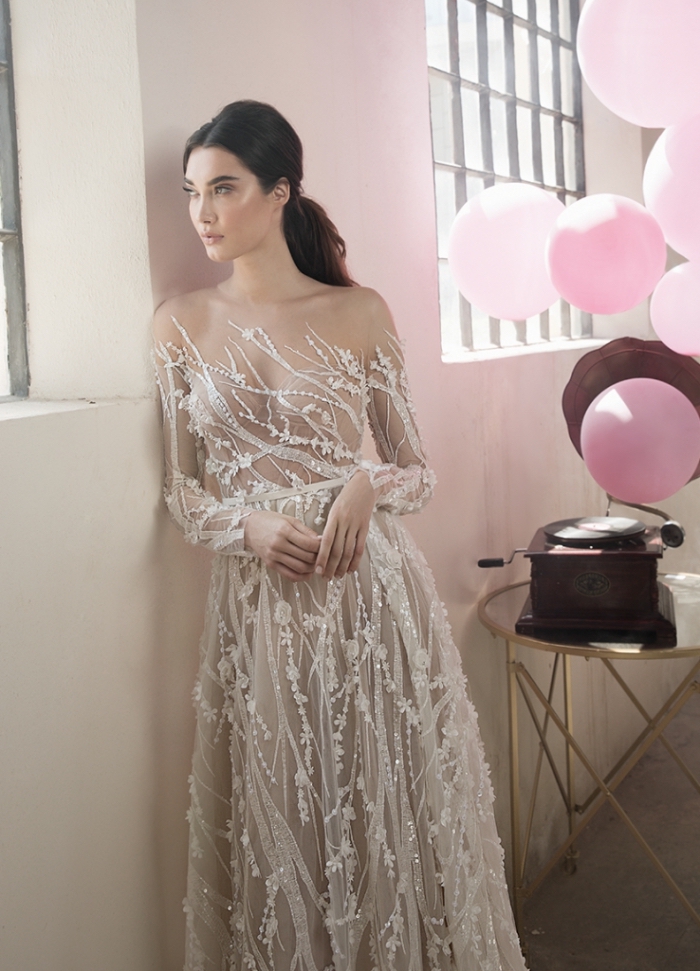 coupe-princesse-robe-de-mariée-bustier-leegrebenau-bustier-illusion-manches-transparentes-dentelle-perlée-jupe-tulle-coiffure-cheveux-en-queue-basse design féerique de robe de mariée originale en tulle, couleur robe de mariée nude avec applications de dentelle perlée