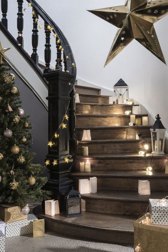 deco cage d'escalier féerique pour la fête de noël, de petites bougies et des lanternes qui illuminent l'escalier en bois et noir