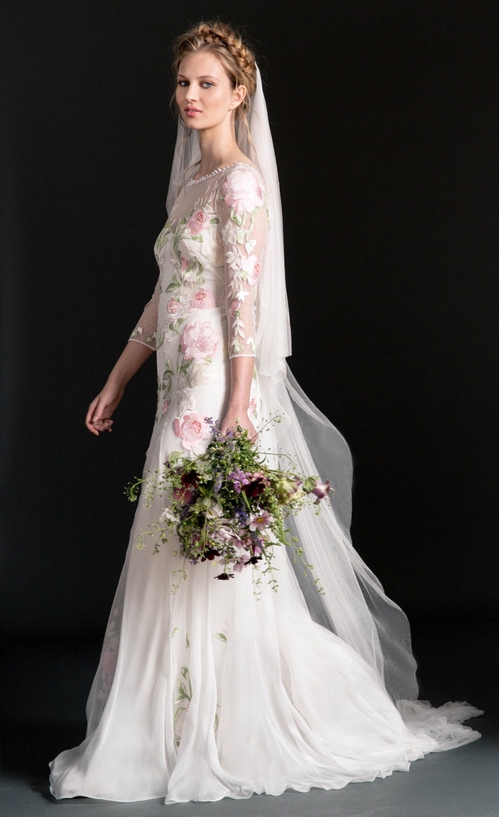 effet-de-tatouage-tendances-robe-mariée-pas-cher-modèle-robe-temperleylondon-avec-fleurs-brodées-en-rose-pastel-et-feuilles-vertes-traîne-mousseline-et-tulle idée robe de mariée champetre à col montant transparent et fleurs brodées en couleurs, coiffure bohème en couronne tressée
