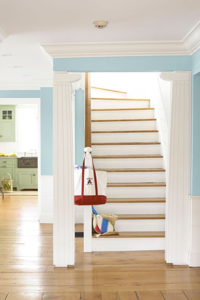 escalier bois et blanc plein de luminosité qui s'accorde parfaitement avec l'ambiance claire de l'entrée blanc et bleu ciel