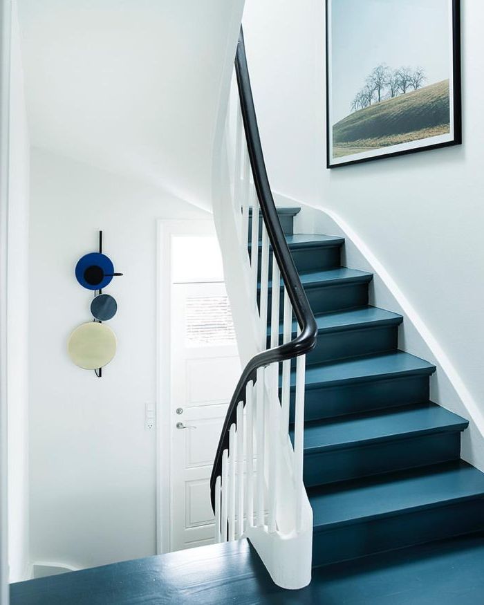repeindre un escalier en bleu pétrole pour lui donner un look contemporain, des touches de noir sur le garde-corps et le cadre photo apportent de l'élégance à la cage d'escalier