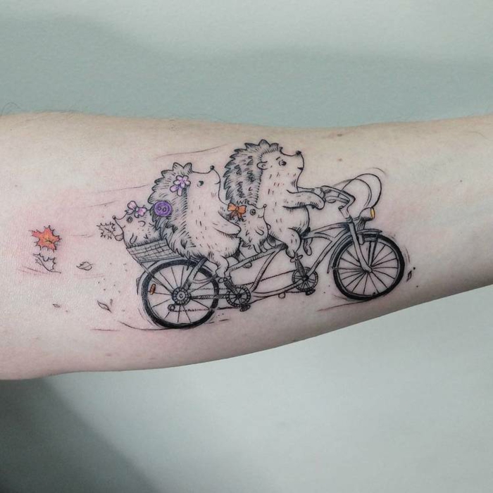 Mignon tatouage dessin stylisé de deux hérissons avec ses enfants sur une bicyclette, choisir le style de son tatouage noir et details colorés