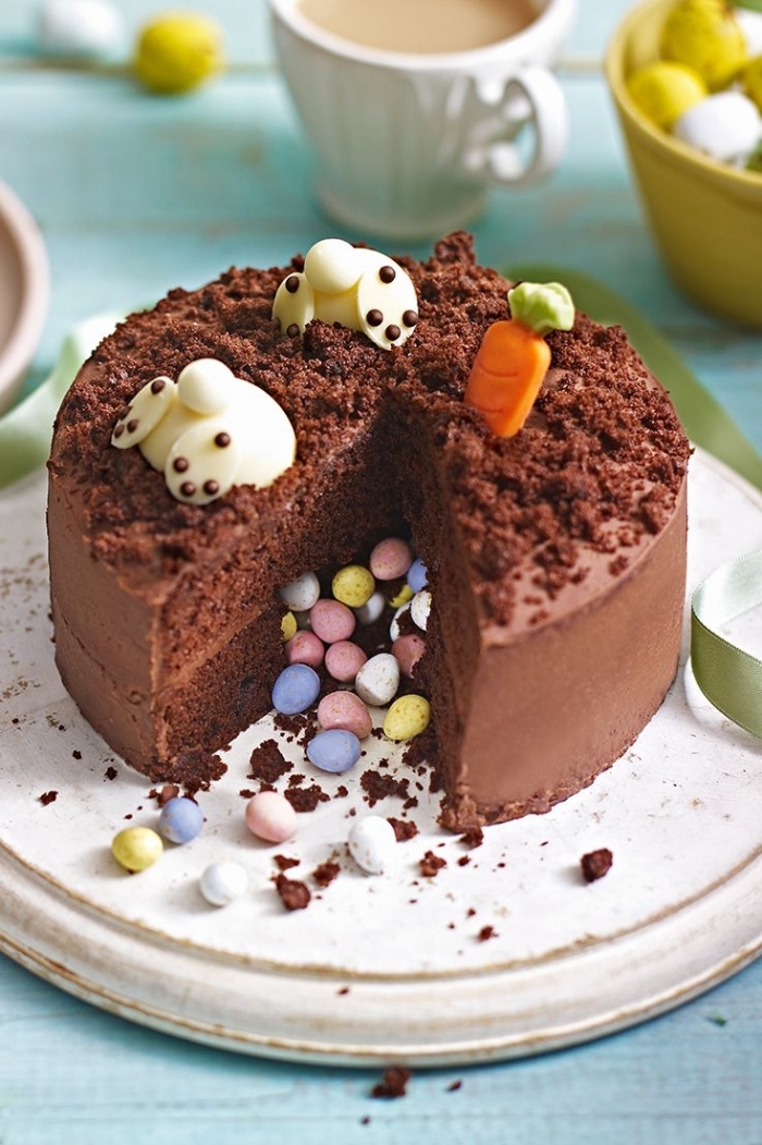 pinata cake au chocolat décoré pour pâques avec deux lapins en pâte d'amande avec têtes plongées dans le gâteau