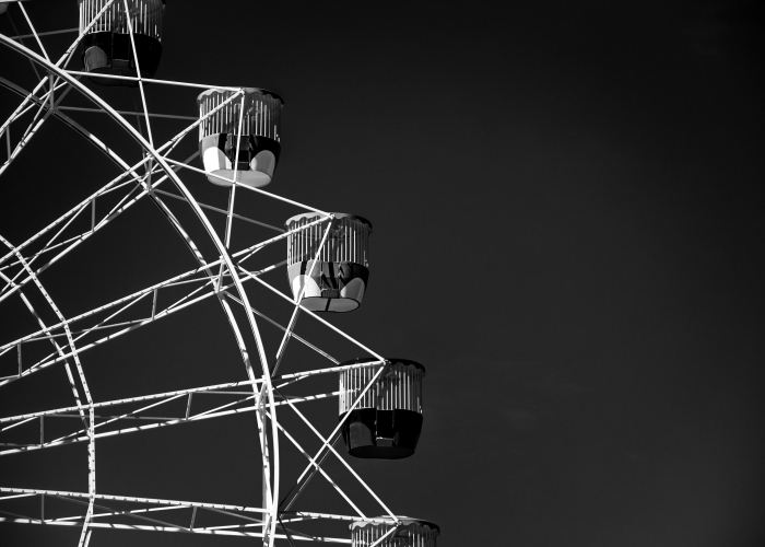 belle photo noir et blanc artistique d'une roue géante qui se détache sur le fond du ciel noir, photographie monochrome