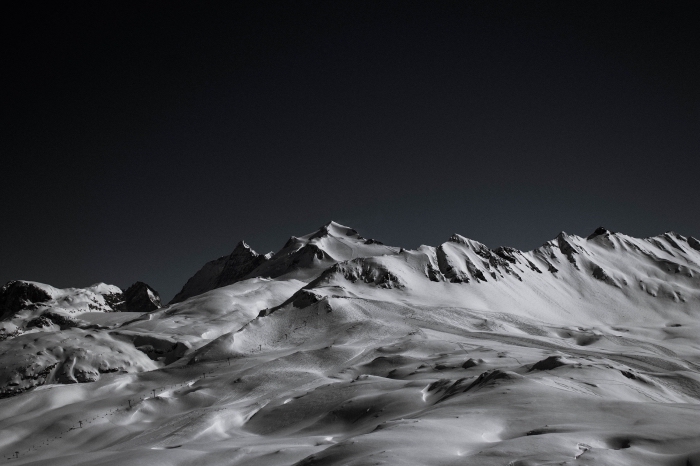 la blancheur d'une crête de montagne rocheuse couverte de neige qui se détache sur le fond du ciel noir, les plus belles images de paysages de montagne noir et blanc