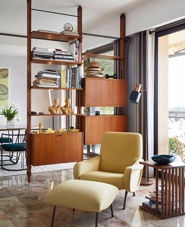 meuble de separation en bois avec des étagères et tiroirs séparer un salon et salle a manger, fauteuil jaune, carrelage de luxe